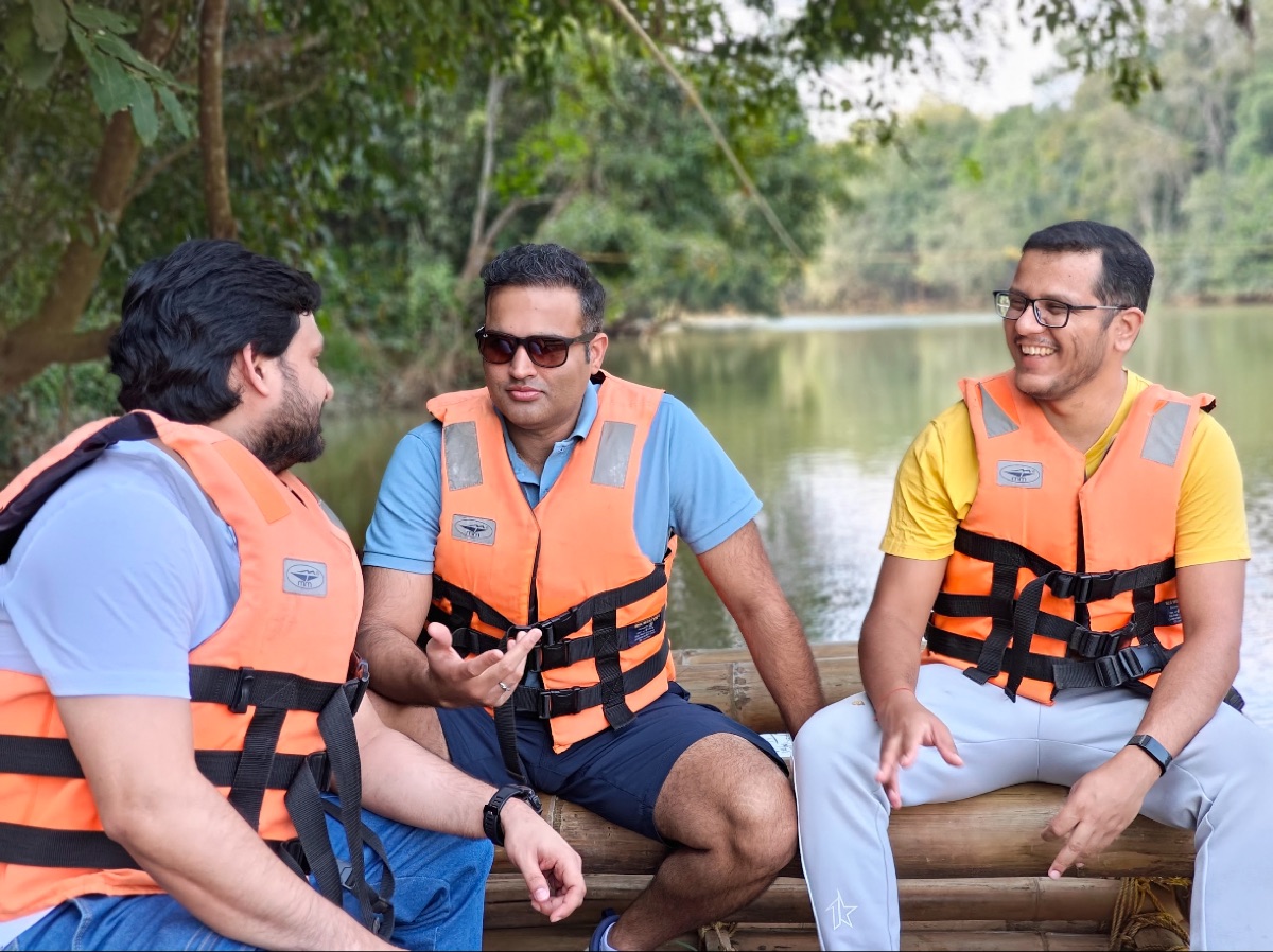 Friends on a Kerala trip, laughing on a bamboo raft
